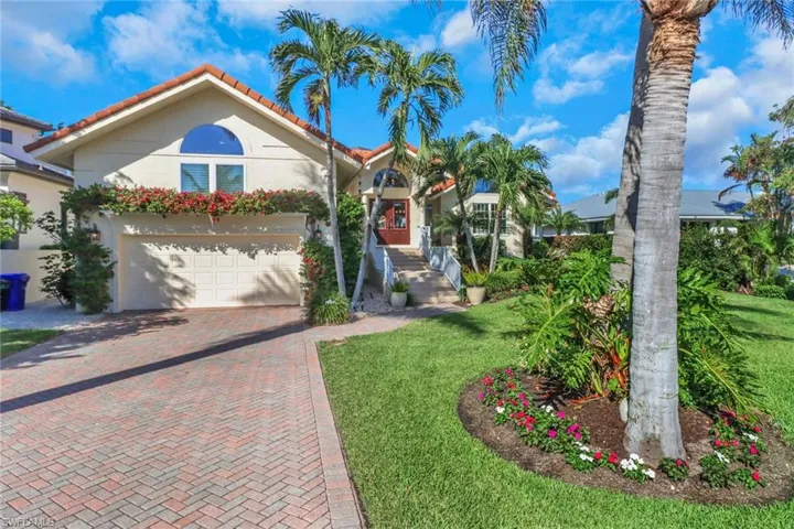 Mediterranean / spanish house featuring decorative driveway, a front lawn, stucco siding, and a tiled roof