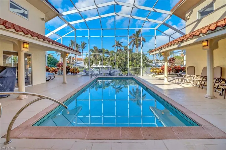Outdoor pool with a patio area, a sunroom, and a lanai