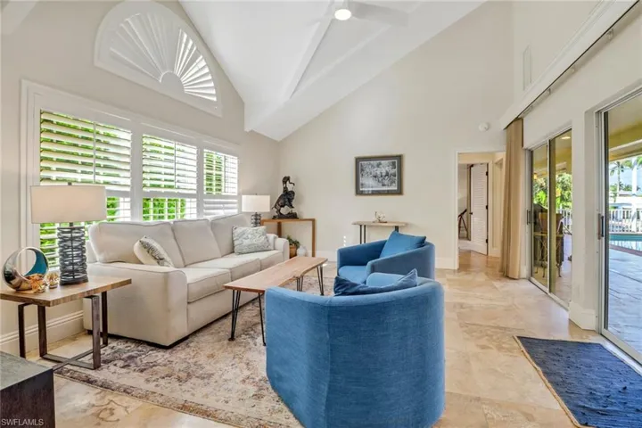Living room featuring high vaulted ceiling, healthy amount of natural light, and ceiling fan