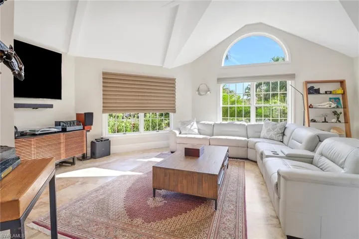 Living area with healthy amount of natural light and high vaulted ceiling