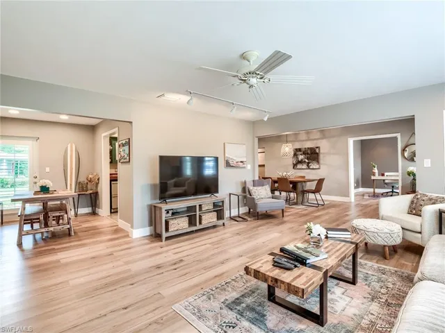 Living room featuring ceiling fan, light wood-type flooring, and rail lighting