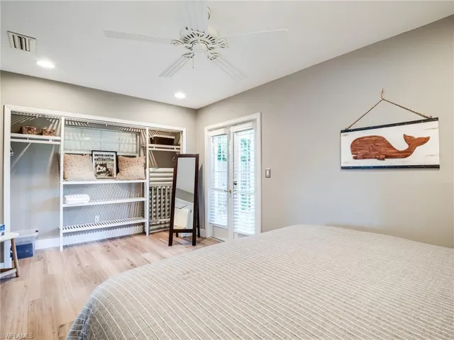 Bedroom with ceiling fan, a closet, light hardwood / wood-style flooring, french doors, and access to outside