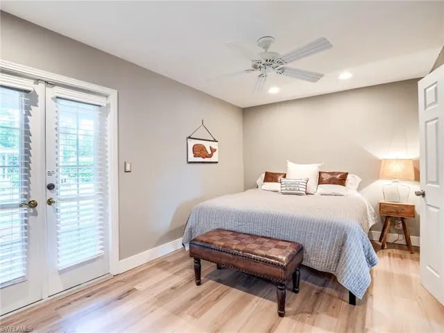 Bedroom with multiple windows, light hardwood / wood-style floors, and access to outside
