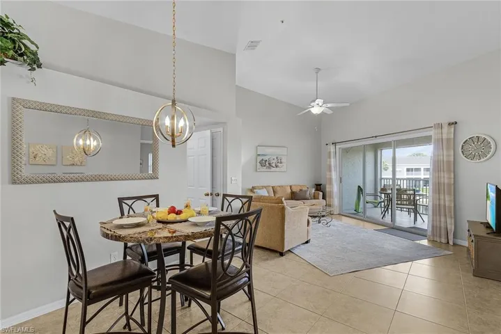 Dining space with ceiling fan, high vaulted ceiling, and light tile patterned floors