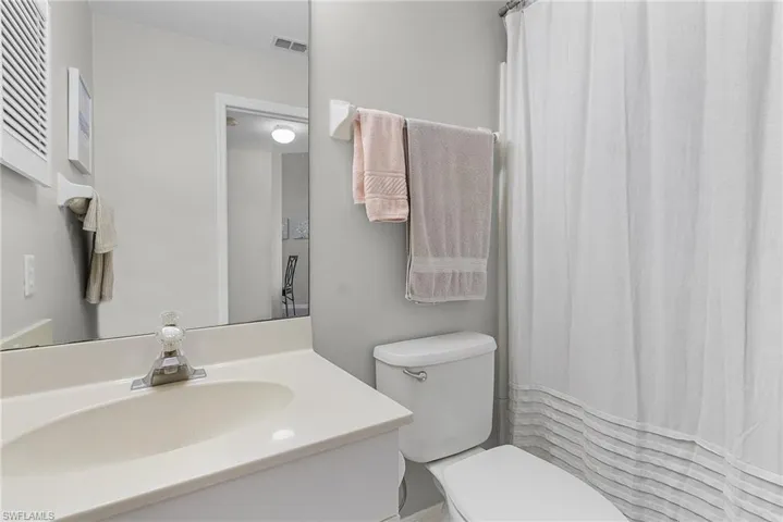 Full bath featuring curtained shower and vanity