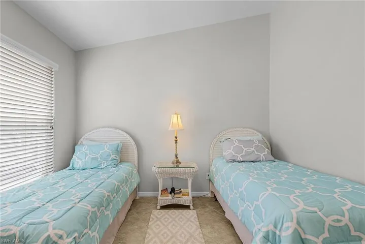 Bedroom with baseboards and tile patterned flooring