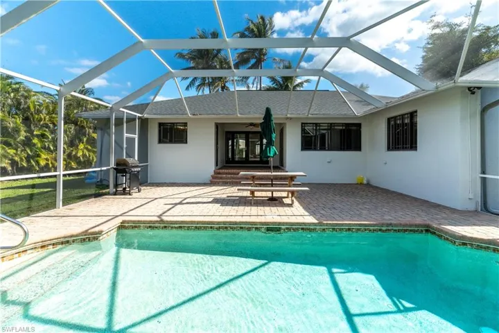 View of swimming pool featuring ceiling fan, grilling area, a lanai, and a patio