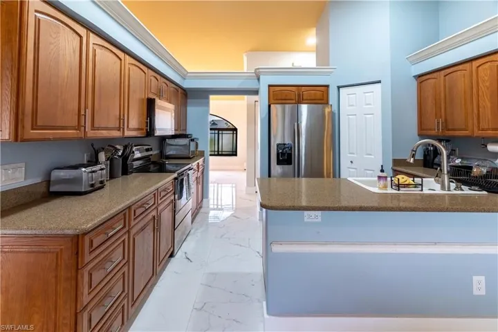 Kitchen featuring appliances with stainless steel finishes, kitchen peninsula, and sink