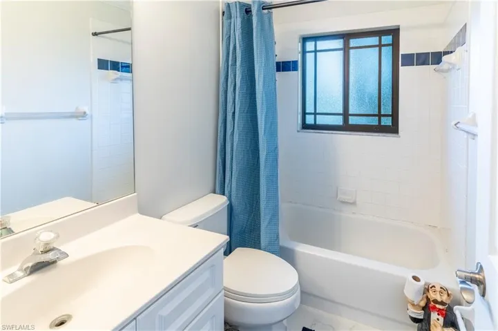 Full bathroom featuring vanity, shower / bathtub combination with curtain, and toilet