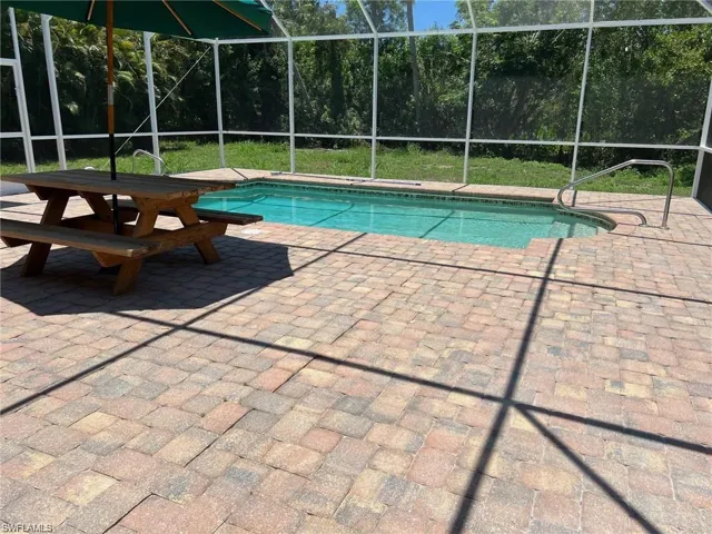 Outdoor pool featuring a lanai, a sunroom, and a patio