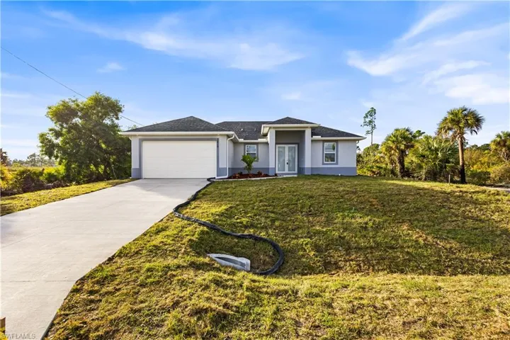 Ranch-style home featuring a front yard and a garage