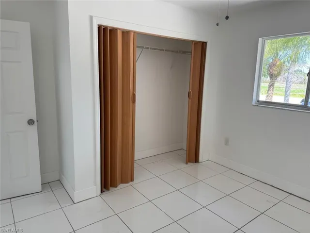 Unfurnished bedroom featuring a closet and light tile patterned flooring
