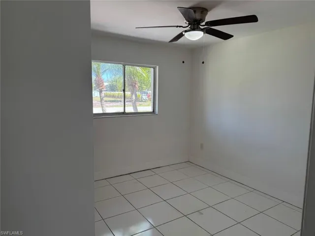 Unfurnished room featuring light tile patterned floors and ceiling fan