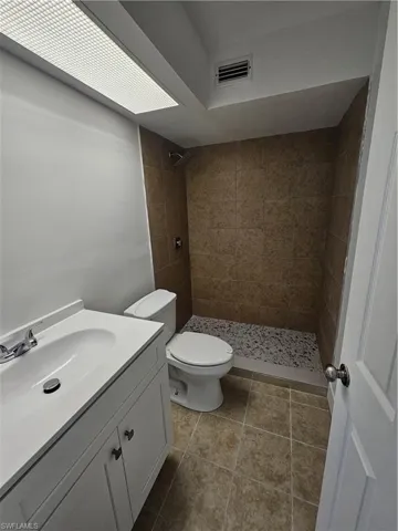 Full bathroom featuring a tile shower and vanity