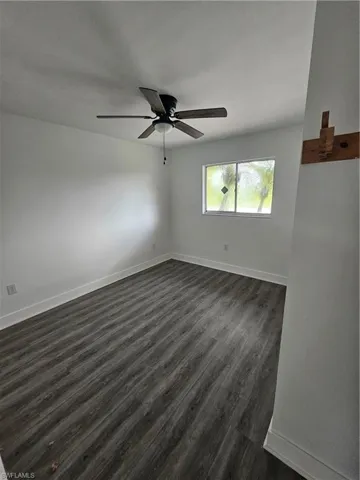Empty room featuring dark wood finished floors and ceiling fan
