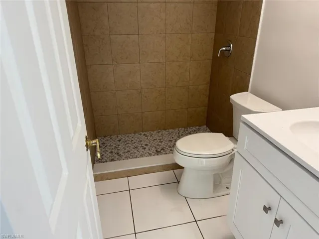 Bathroom with vanity, a shower stall, and tile patterned floors