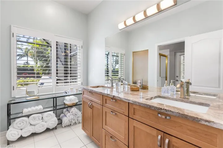 Redesigned primary ensuite bathroom offers granite countertops on a comfort height dual vanity.