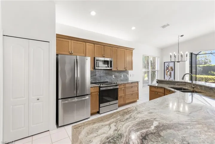 Beautifully redesigned kitchen offers a oversized island, stainless steel appliances, honey cabinetry.