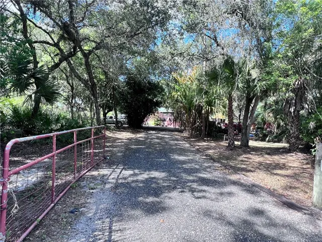 View of dirt / gravel driveway with a gated entry