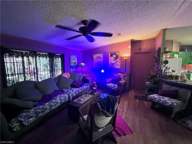 Living room with ceiling fan and dark wood finished floors