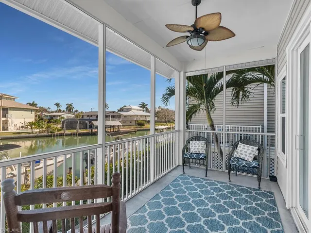 Sunroom / solarium with a water view and a residential view