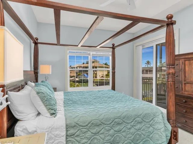 Carpeted bedroom with ceiling fan and access to exterior