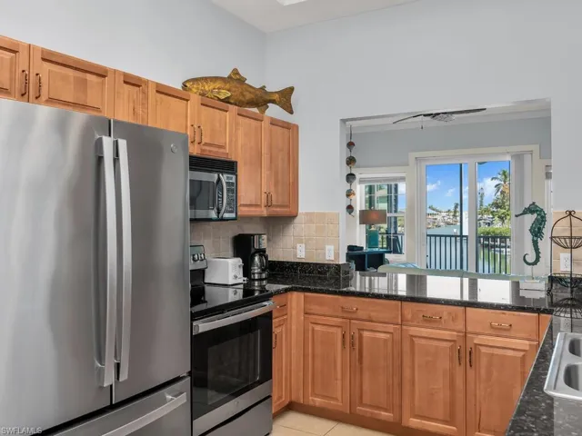 Kitchen featuring stainless steel appliances, brown cabinetry, tasteful backsplash, and a water view