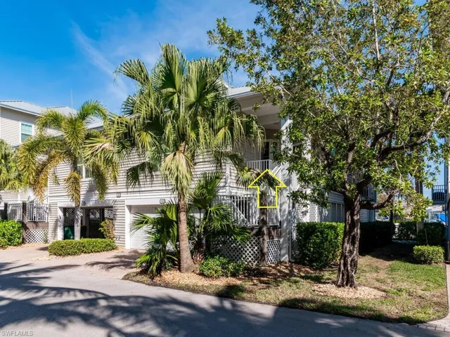 Obstructed view of property with a garage, a balcony, and driveway