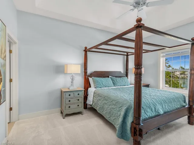 Bedroom with ceiling fan and light colored carpet