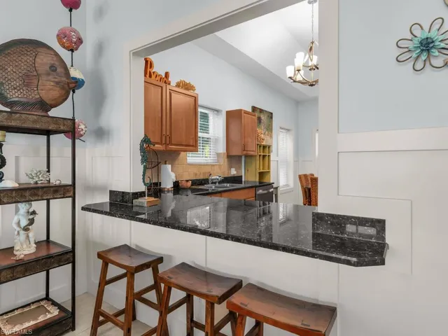 Kitchen featuring brown cabinetry, a kitchen breakfast bar, tasteful backsplash, and a peninsula