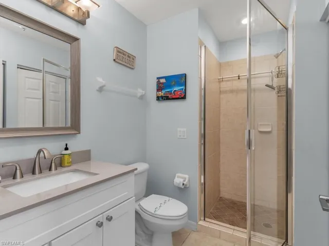 Bathroom with vanity, a shower stall, and light tile patterned flooring