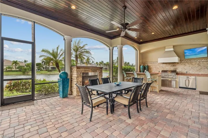 View of patio with ceiling fan, a grill, a water view, and exterior kitchen