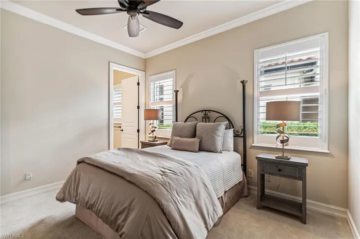 bedroom featuring multiple windows, ceiling fan, and crown molding