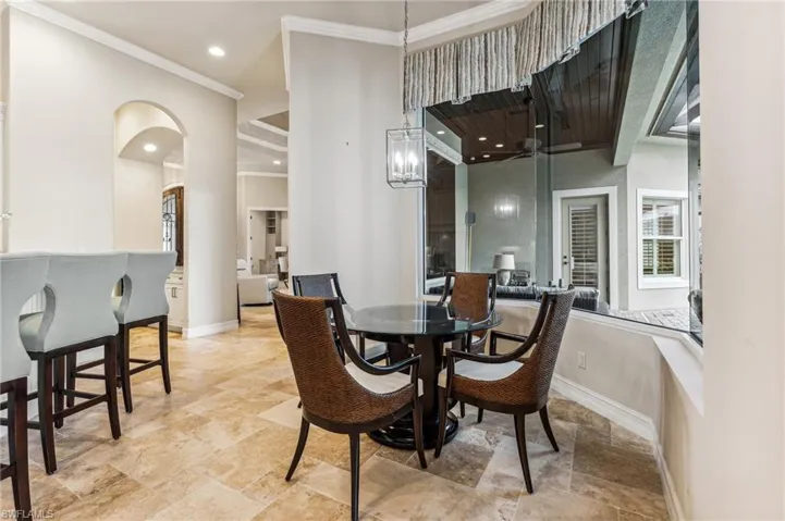 Dining space with a notable chandelier and ornamental molding