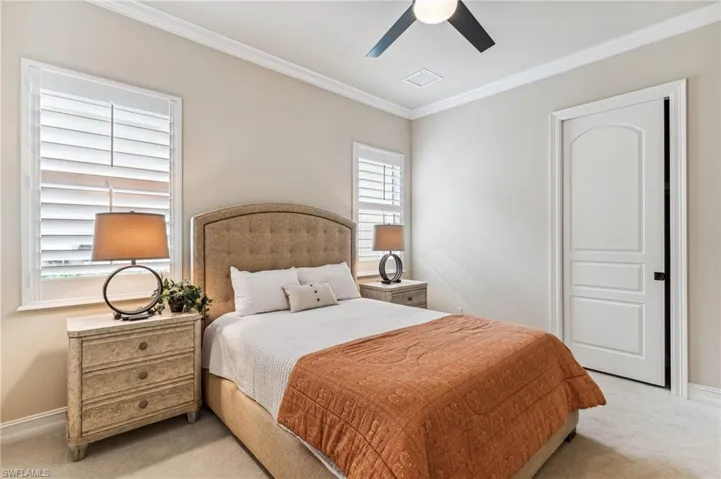 Bedroom with ceiling fan, multiple windows, and crown molding