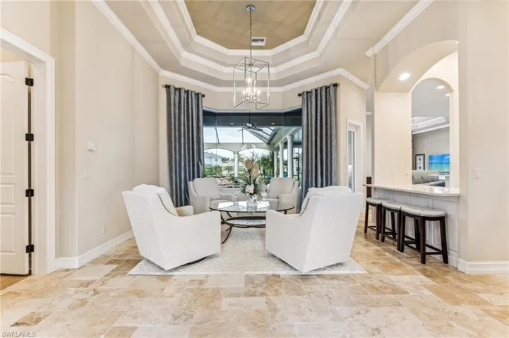 Sitting room with crown molding, a tray ceiling, and an inviting chandelier
