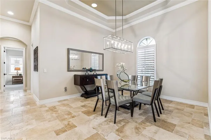 Dining area with a towering ceiling, an inviting chandelier, and crown molding