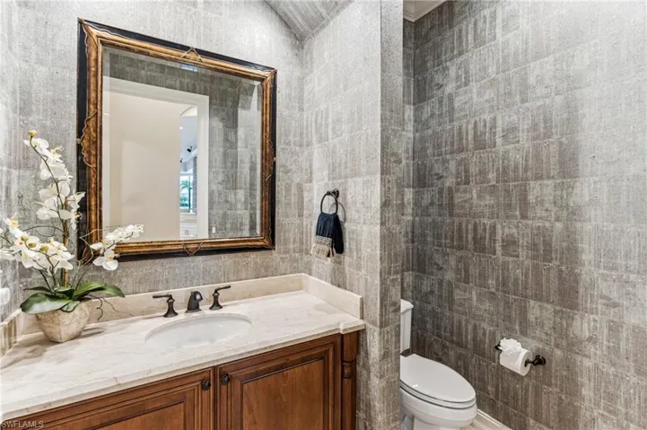 Bathroom with tile walls, vanity, and toilet
