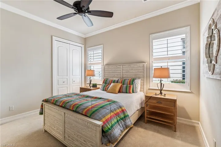 Bedroom with ceiling fan, multiple windows, a closet, and ornamental molding