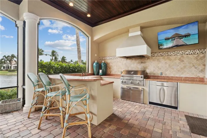 View of patio / terrace featuring an outdoor kitchen, area for grilling, a water view, and sink