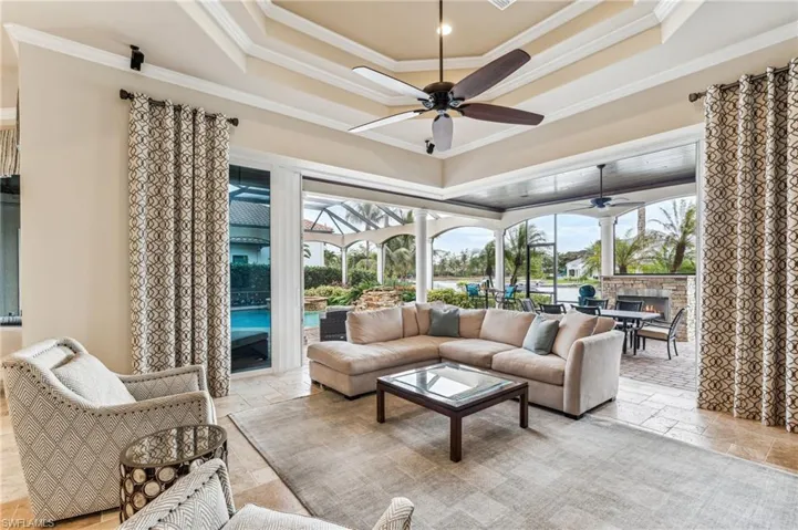 Living room with a healthy amount of sunlight, crown molding, and ceiling fan