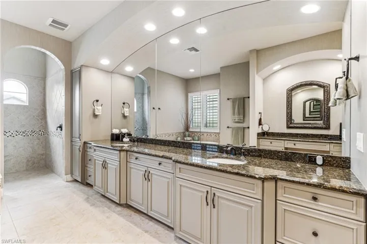 Bathroom featuring vanity and a tile shower