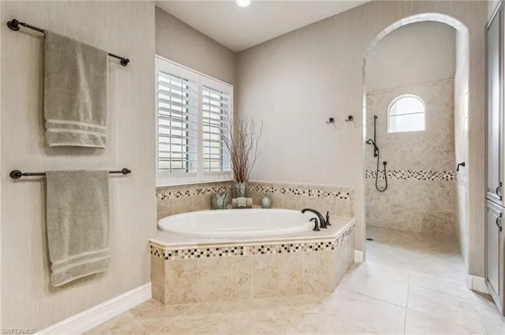 Bathroom featuring a wealth of natural light, tile patterned floors, and independent shower and bath