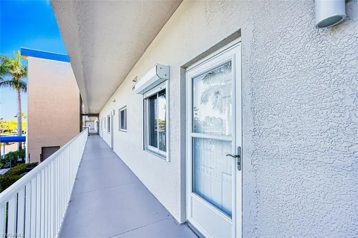 Doorway to property with a balcony and stucco siding