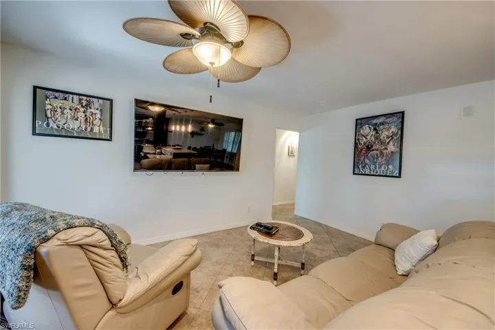 Tiled living room featuring baseboards and ceiling fan