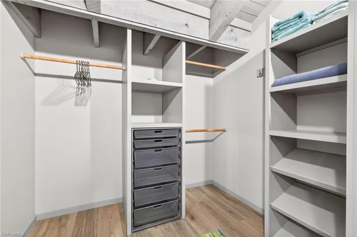 Walk in closet with light wood-style floors
