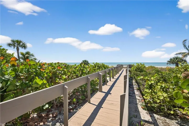 Wooden deck with view of water and beach