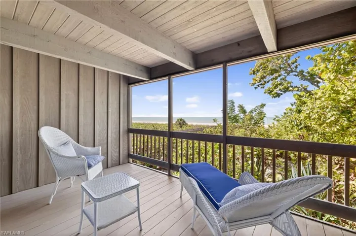 Sunroom featuring beamed ceiling and a water view