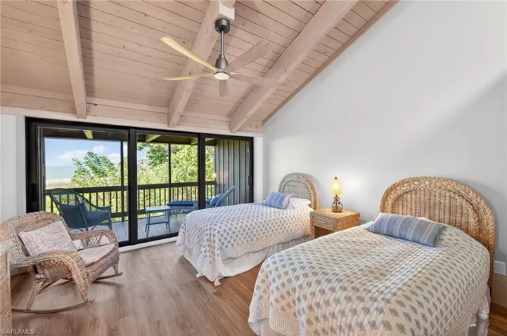 Bedroom featuring access to outside, wood finished floors, lofted ceiling with beams, a ceiling fan, and wooden ceiling