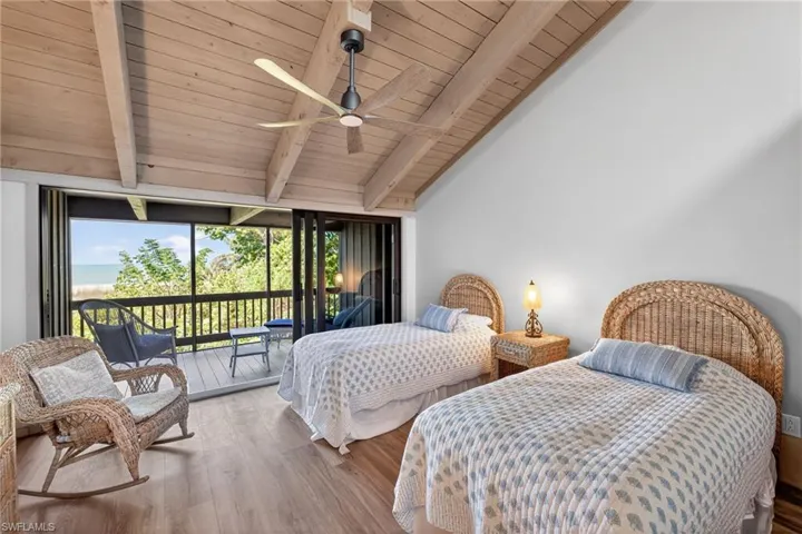 Bedroom featuring access to exterior, wood finished floors, vaulted ceiling with beams, wooden ceiling, and a ceiling fan